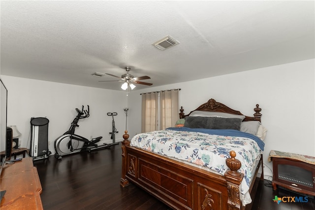 bedroom with ceiling fan, a textured ceiling, and dark hardwood / wood-style flooring