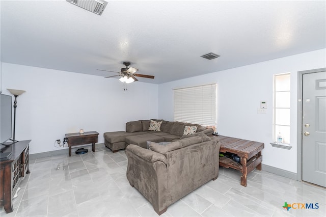 living room featuring a textured ceiling and ceiling fan