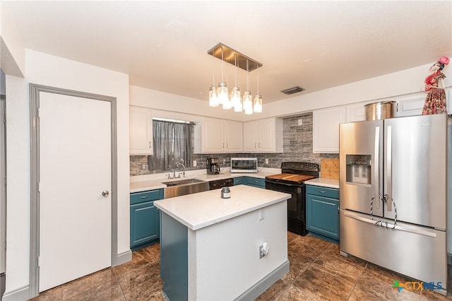 kitchen featuring stainless steel appliances, blue cabinetry, a center island, white cabinets, and decorative backsplash