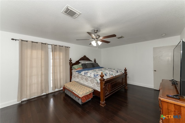 bedroom featuring dark wood-type flooring, ceiling fan, and a textured ceiling