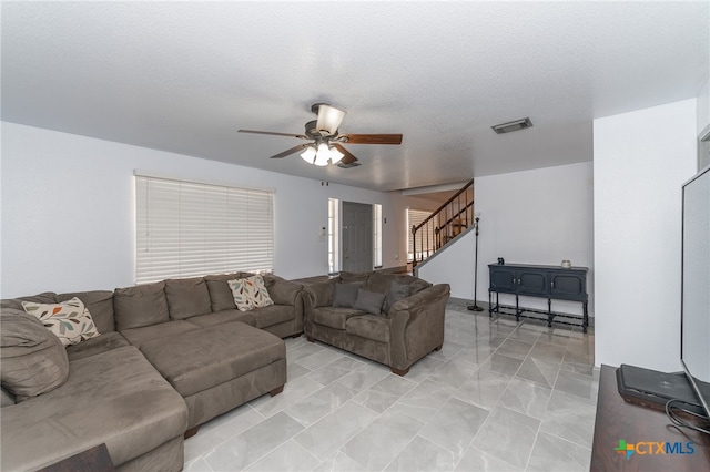 living room featuring a textured ceiling and ceiling fan