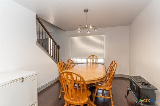 dining space featuring dark hardwood / wood-style flooring and an inviting chandelier