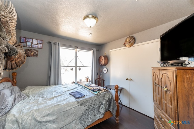 bedroom with dark wood-type flooring and a textured ceiling