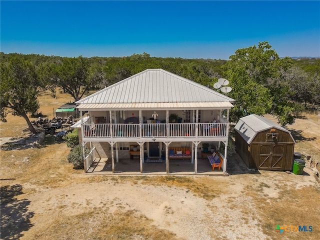 view of front of home with a storage shed and a patio area