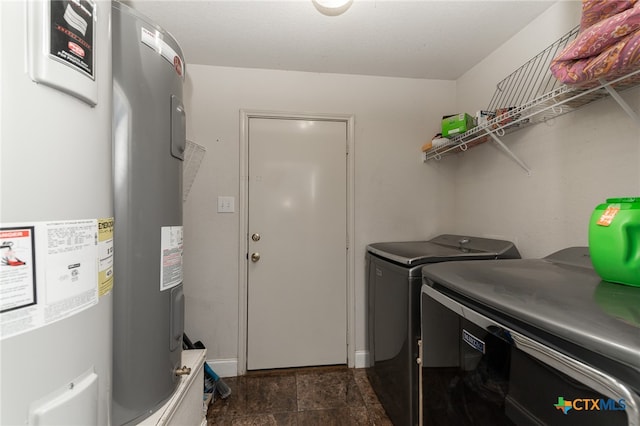 laundry area with water heater and washing machine and clothes dryer