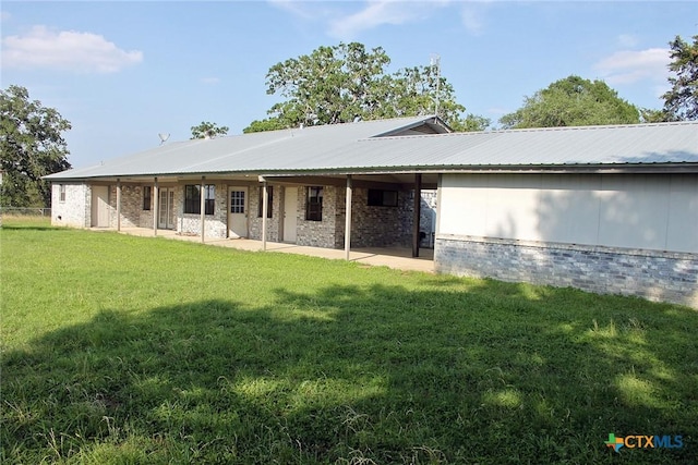 854 Pettytown Rd, Red Rock, TX 78662 - back of property featuring a patio area, a yard, metal roof, and brick siding