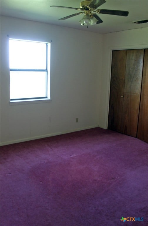 unfurnished bedroom with carpet flooring, ceiling fan, and a closet