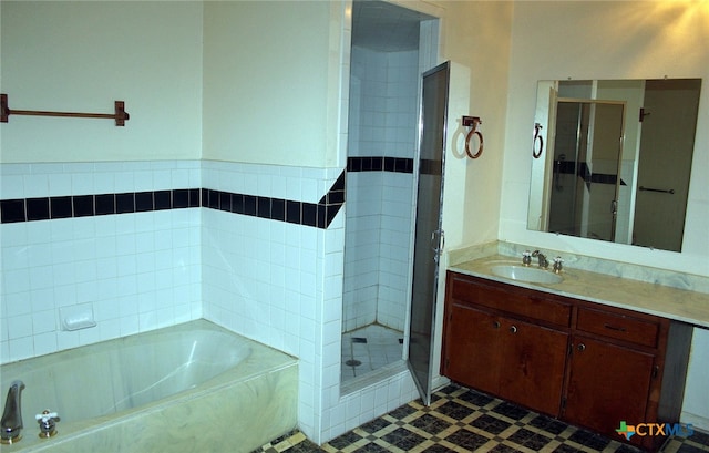 bathroom featuring vanity, shower with separate bathtub, and tile patterned floors