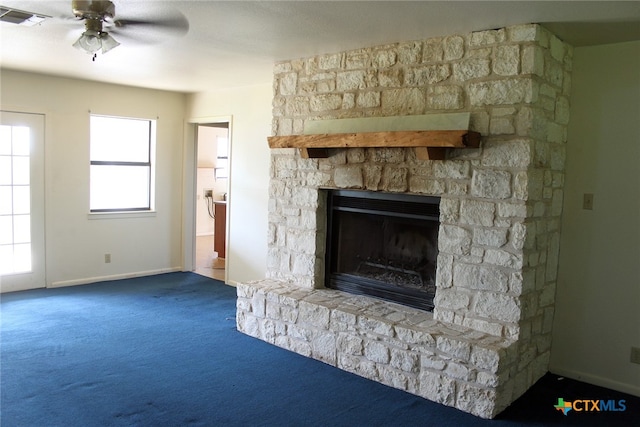 details featuring ceiling fan, a stone fireplace, and carpet