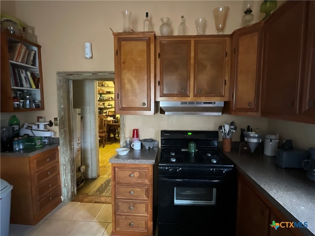 kitchen with light tile patterned floors, black range with electric stovetop, and exhaust hood