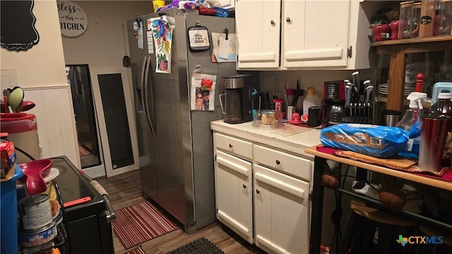 701 E Anaqua Ave, Victoria, TX 77901 - kitchen with tile counters, stainless steel refrigerator with ice dispenser, white cabinets, wood finished floors, and wainscoting