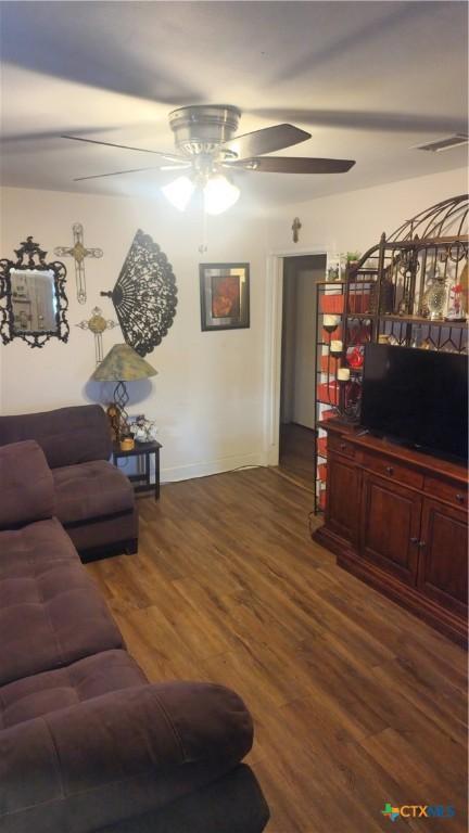 701 E Anaqua Ave, Victoria, TX 77901 - living area with a ceiling fan, dark wood-style flooring, and baseboards