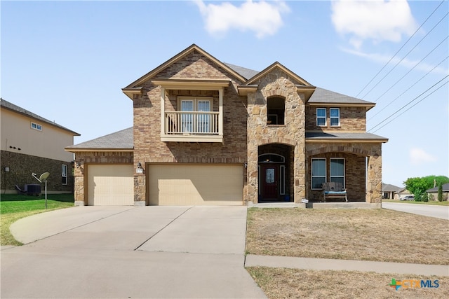 view of front of home with central AC unit, a garage, and a balcony