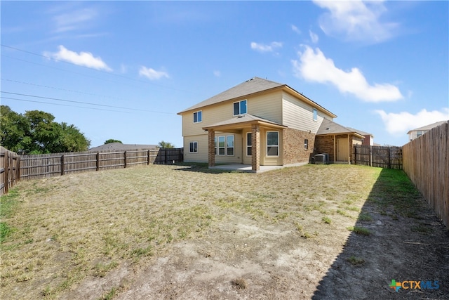 back of house featuring a patio and a lawn