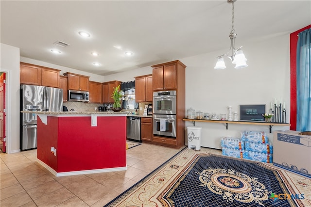 kitchen with hanging light fixtures, stainless steel appliances, an inviting chandelier, kitchen peninsula, and a breakfast bar