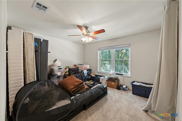 living room featuring a textured ceiling, light carpet, and ceiling fan