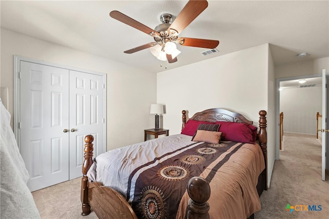 bedroom featuring ceiling fan, light colored carpet, and a closet