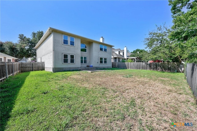 rear view of house featuring a lawn