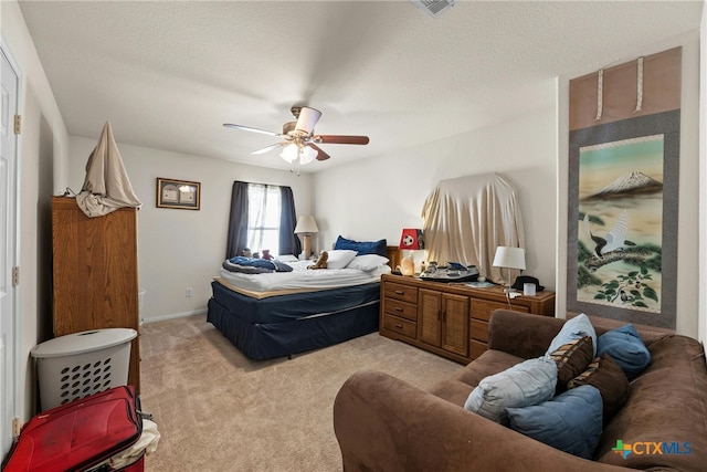 carpeted bedroom with a textured ceiling and ceiling fan