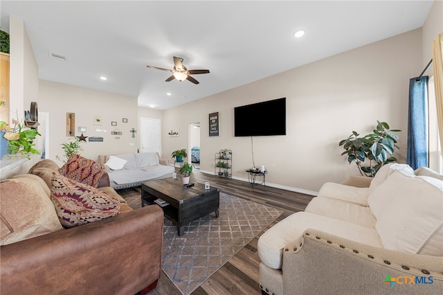 living room with dark hardwood / wood-style flooring and ceiling fan