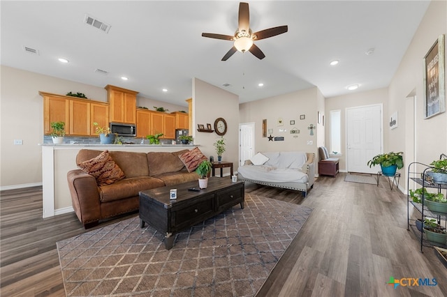 living room featuring dark wood-type flooring and ceiling fan