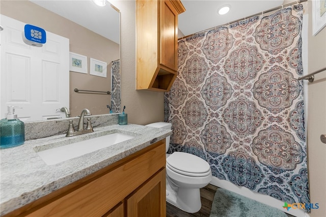 bathroom with toilet, vanity, and hardwood / wood-style floors