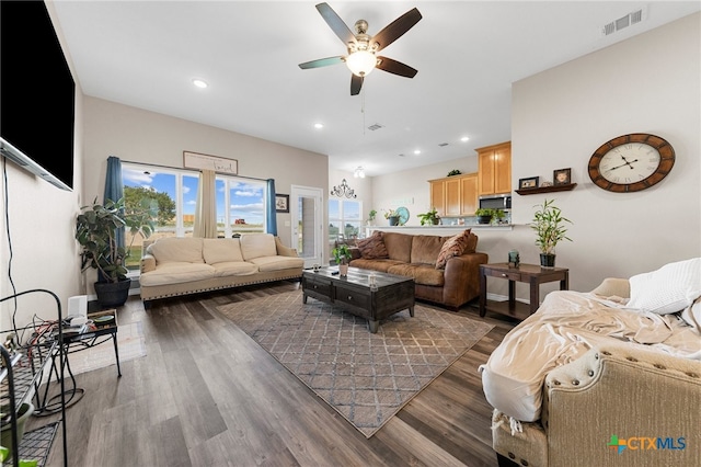 living room with dark wood-type flooring and ceiling fan