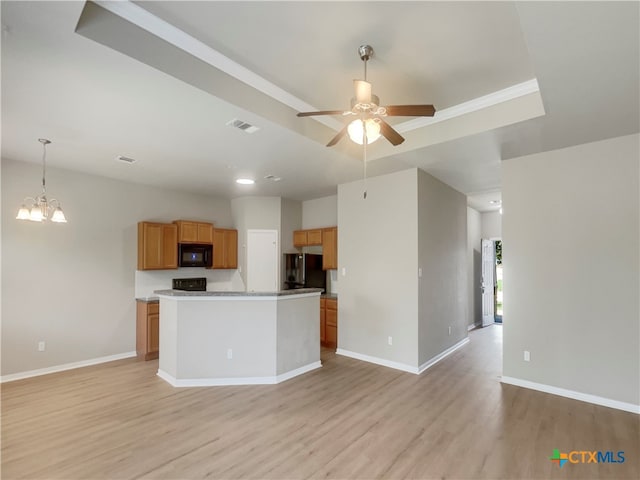 kitchen featuring black appliances, ceiling fan with notable chandelier, hanging light fixtures, light hardwood / wood-style flooring, and a kitchen island