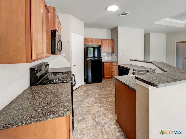 kitchen featuring decorative backsplash, sink, black appliances, and a center island with sink