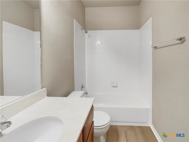 full bathroom featuring hardwood / wood-style flooring, vanity, toilet, and tiled shower / bath