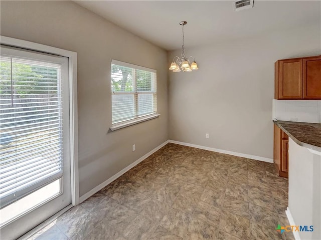 unfurnished dining area featuring an inviting chandelier