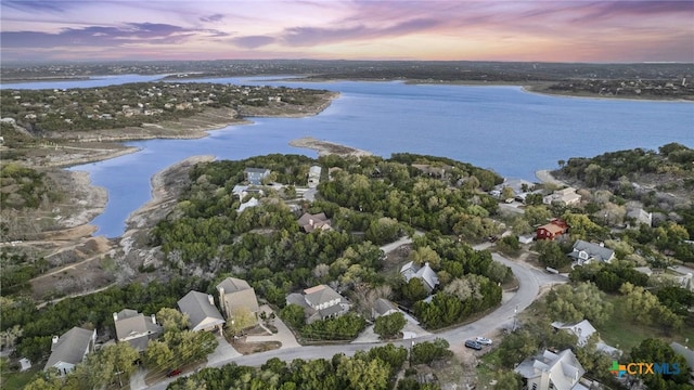 aerial view at dusk featuring a water view