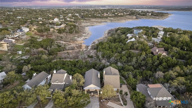 aerial view at dusk featuring a water view