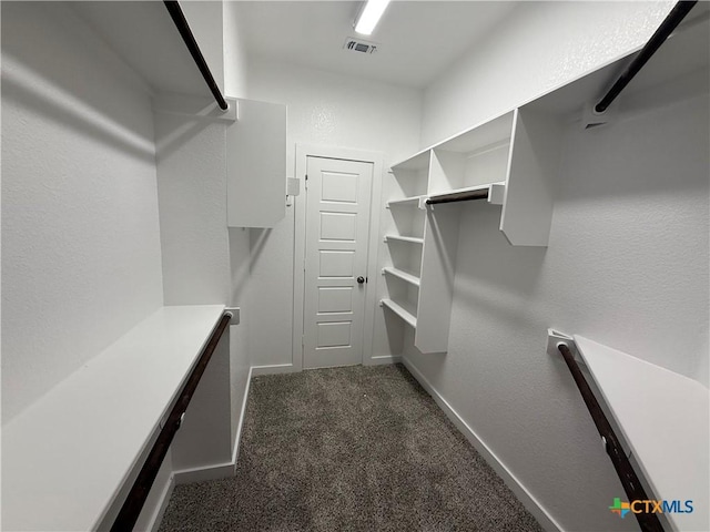 walk in closet featuring dark carpet