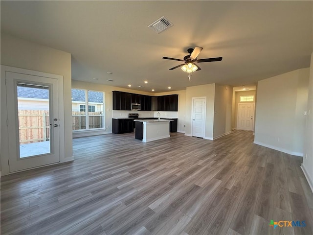 kitchen featuring hardwood / wood-style flooring, ceiling fan, a center island, and sink