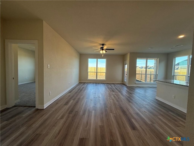 unfurnished living room with a healthy amount of sunlight and dark hardwood / wood-style floors