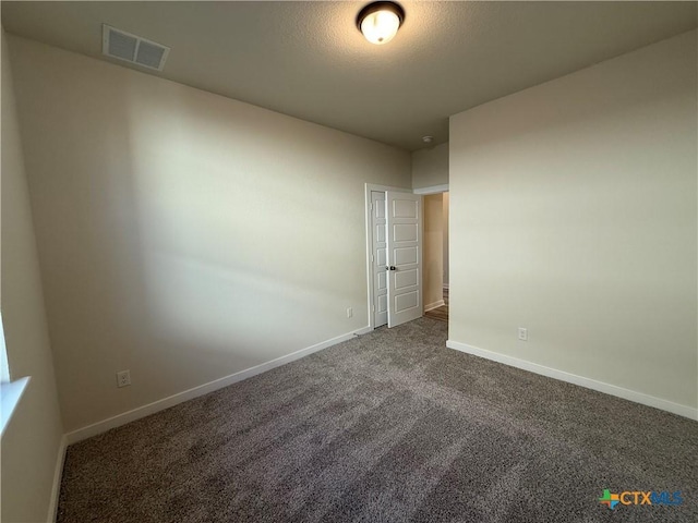 carpeted empty room featuring a textured ceiling