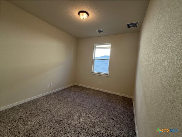 carpeted empty room with a textured ceiling