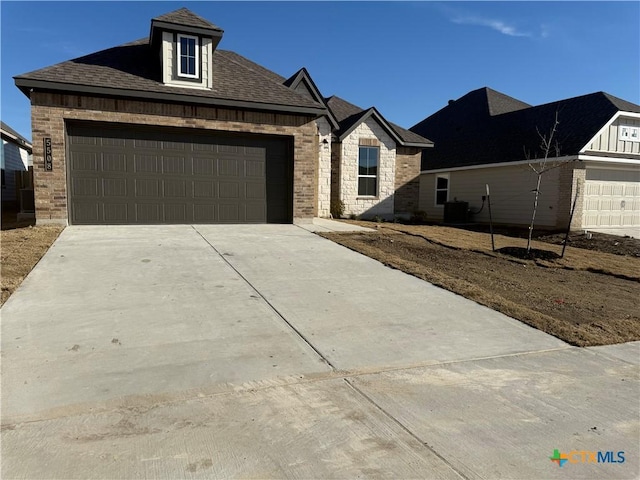 view of front of home featuring central AC unit and a garage