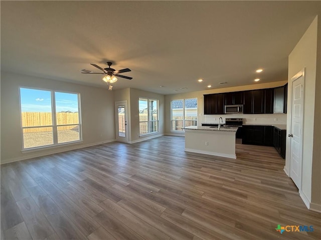 kitchen featuring sink, ceiling fan, a kitchen island with sink, hardwood / wood-style floors, and stainless steel appliances