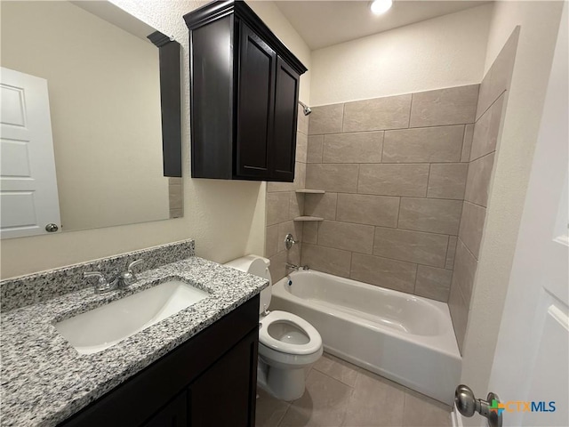 full bathroom featuring tiled shower / bath, vanity, tile patterned floors, and toilet