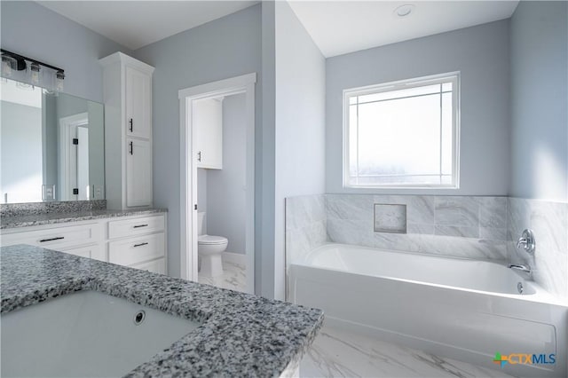 bathroom with vanity, toilet, and a bathtub