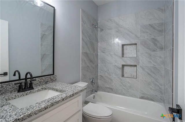 full bathroom featuring tiled shower / bath combo, toilet, and vanity