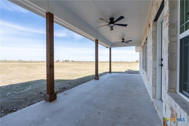 view of patio / terrace featuring ceiling fan and a rural view