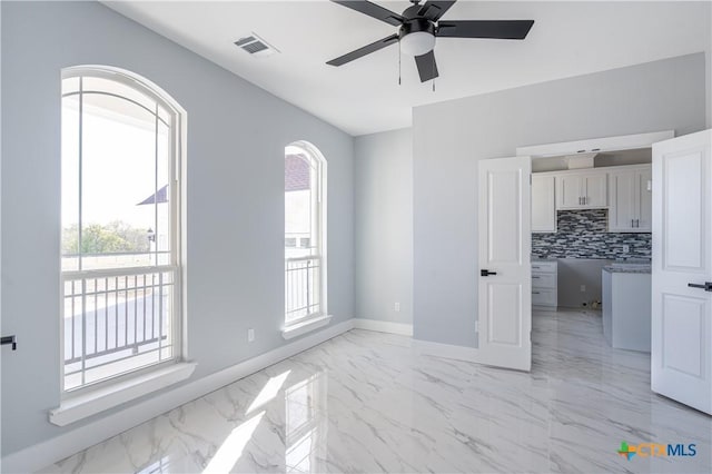 interior space featuring decorative backsplash, plenty of natural light, and ceiling fan