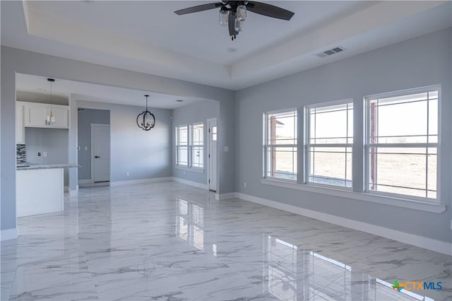 unfurnished room with ceiling fan with notable chandelier