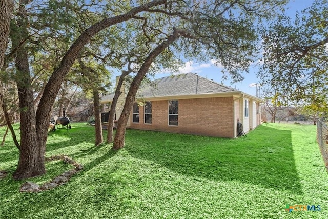 view of side of home with a yard