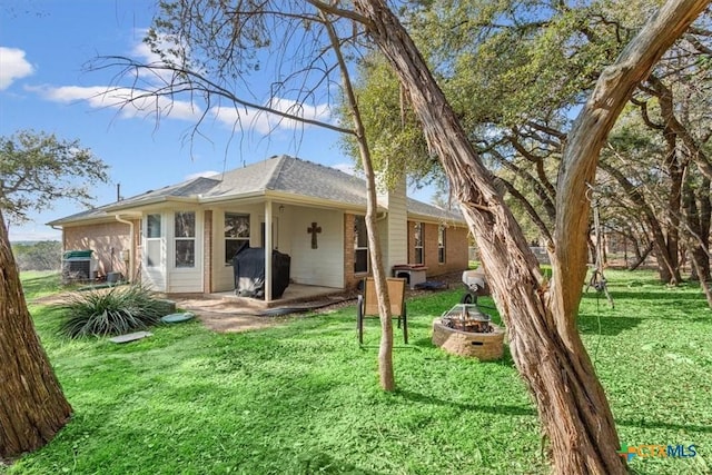 rear view of property with a yard and a patio area