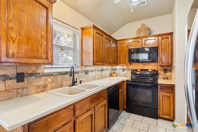 kitchen with lofted ceiling, sink, black appliances, light tile patterned flooring, and decorative backsplash