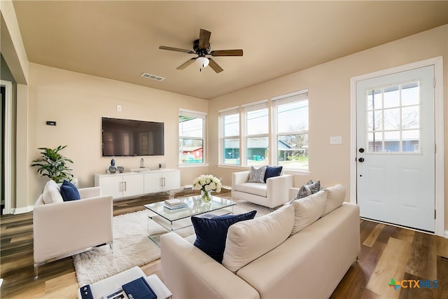 living room featuring visible vents, ceiling fan, and wood finished floors
